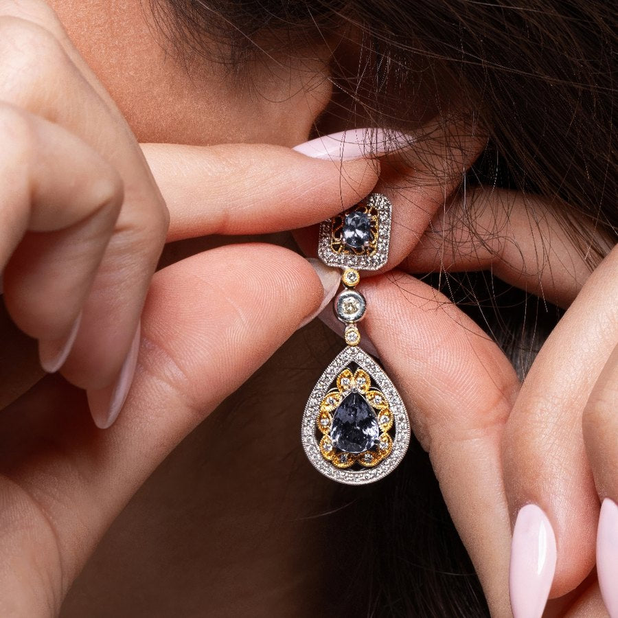 Sapphire and diamond drop earring being put on
