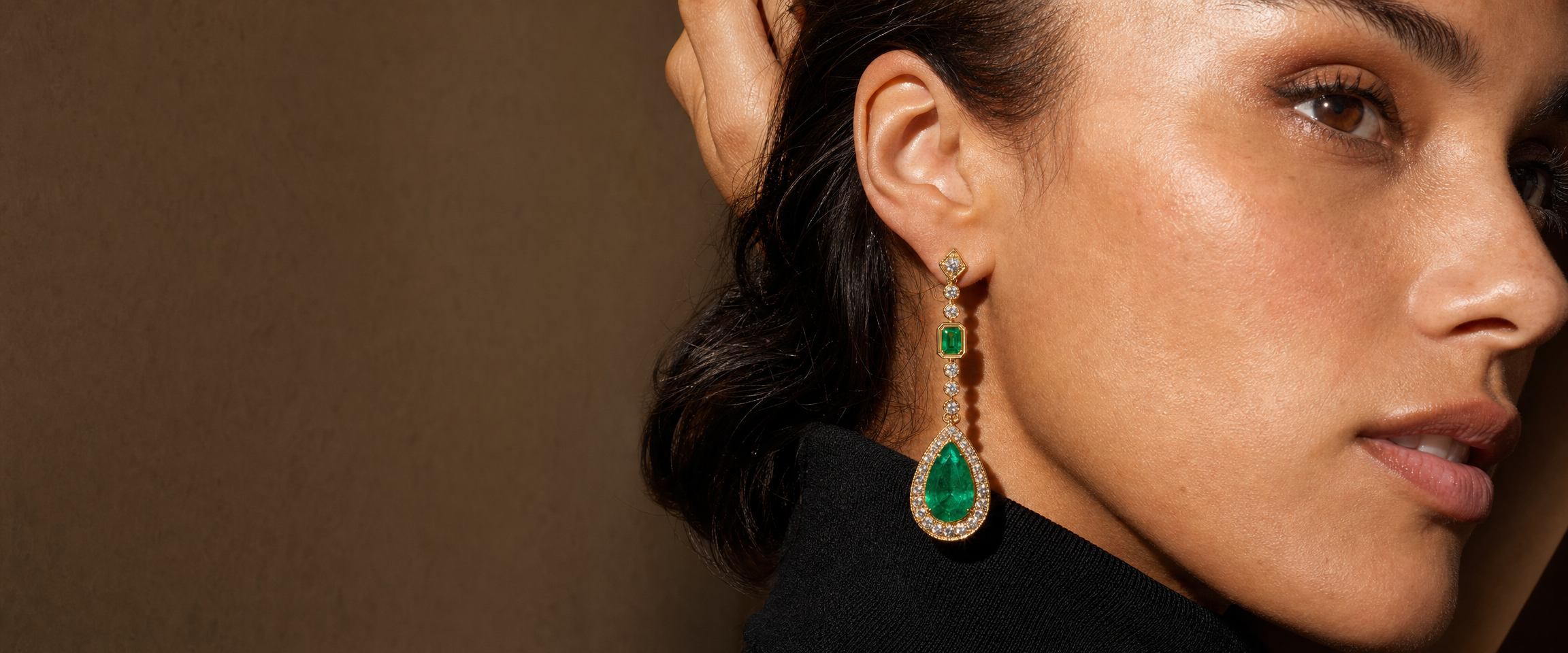 Model wearing emerald and diamond drop earring